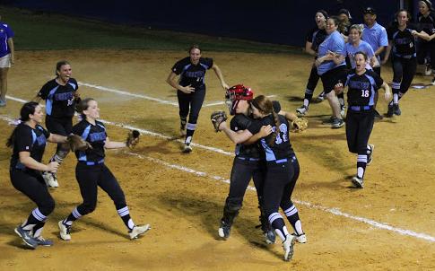 Pitcher Sam Worrell hugs catcher Alicia Tomberlin as the rest of the team runs onto the field to celebrate the regional final victory over West Orange. 