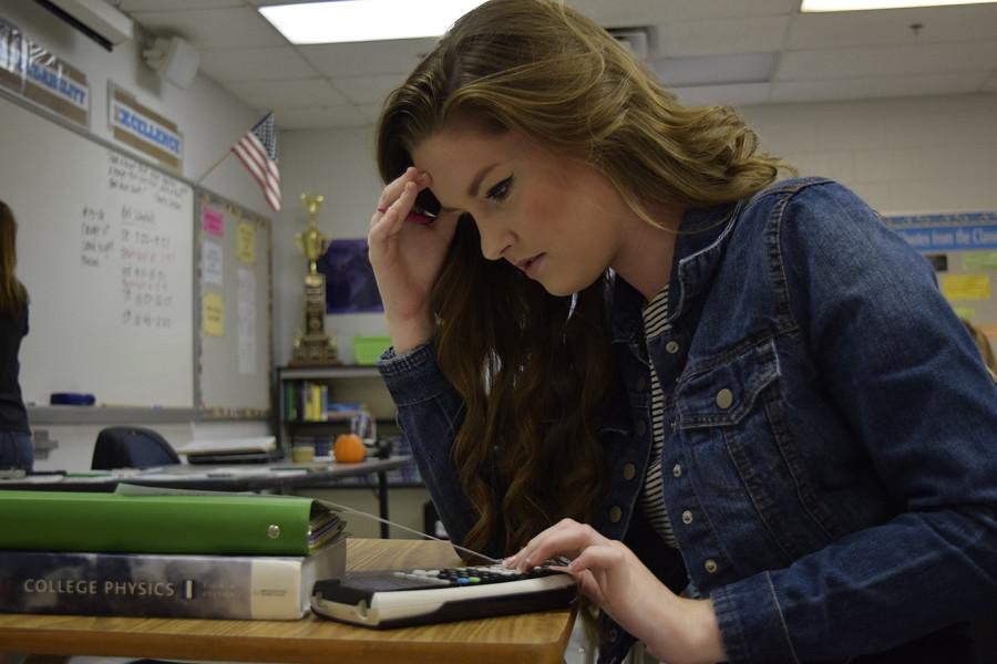 Junior Trinity Turlington rests her head in her hand as she stressfully stares down at her AP Physics classwork.  