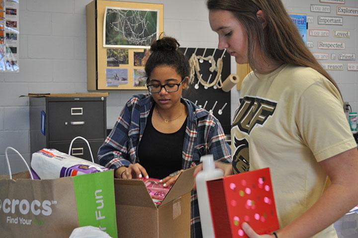 Juniors Tatum Annan and Karly Harms organize the donated items in preparation of sending them off.
