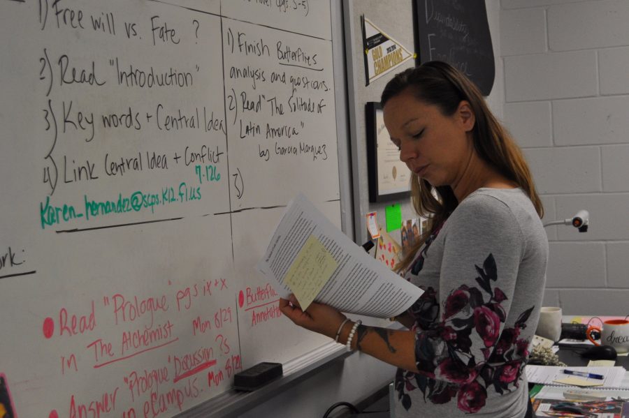 English teacher Lindsey Jackson writes the agenda for her honors classes. Every morning before school starts, Jackson organizes and makes sure all of the materials needed for class are accessible for her students. 