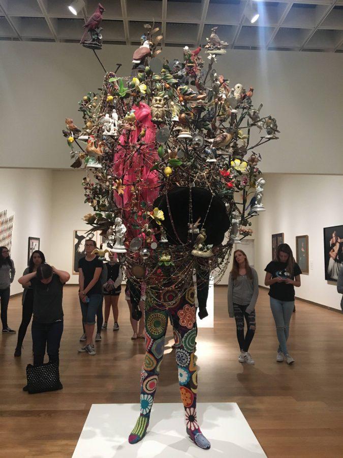 Students looking at and standing around 
Soundsuit 2011, a statue made by Nick Cave on display at the Orlando Museum of Art