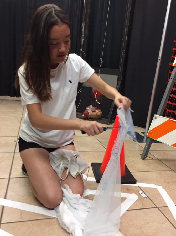 Junior Joy Yun customizes costumes for The Purge house. Volunteers were in charge of customizing their own costumes and making them fit into each of their scaring role. 