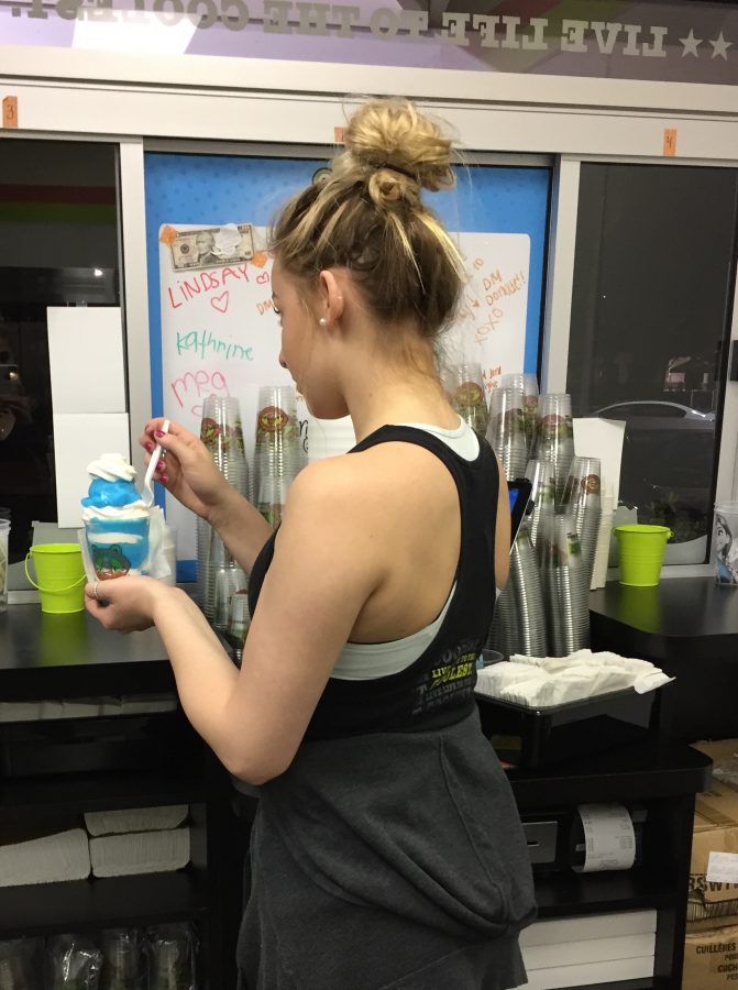 Senior Carly Wieland prepares a gelato for a customer at Jeremiah’s Italian Ice. 