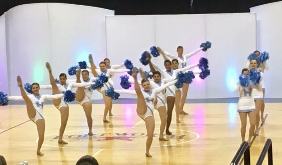 The varsity Unleashed dance team kicks high with smiles on their faces as they perform their pom dance at MA nationals. 