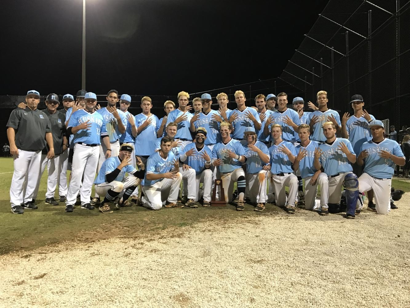 The+varsity+baseball+team+poses+with+the+district+championship+trophy.+They+beat+Lake+Howell+13-3.