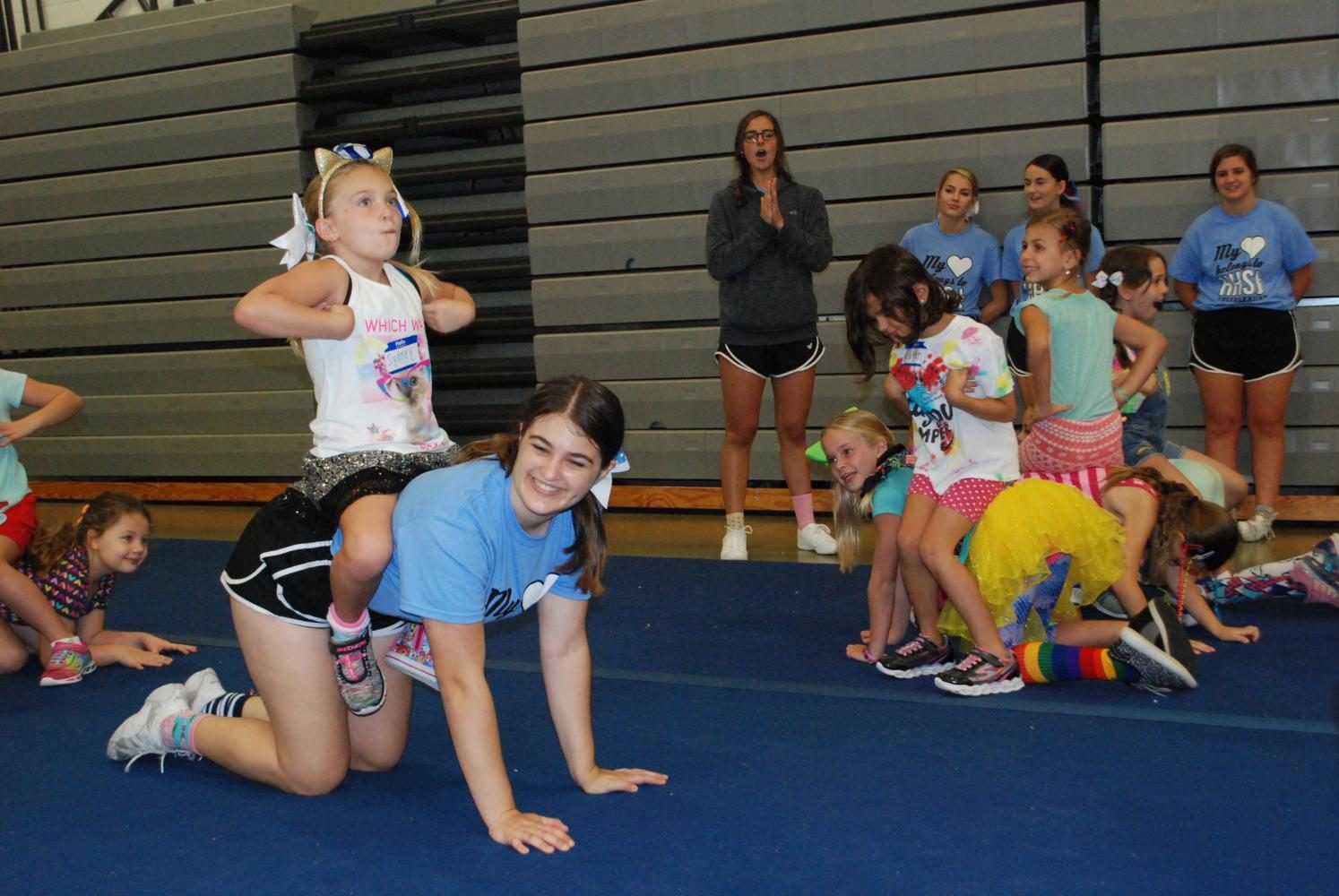 Sophomore Annie Tromboli hangs out with some young cheerleaders during break. She volunteered this summer at Hagertys Youth Cheer Camp.