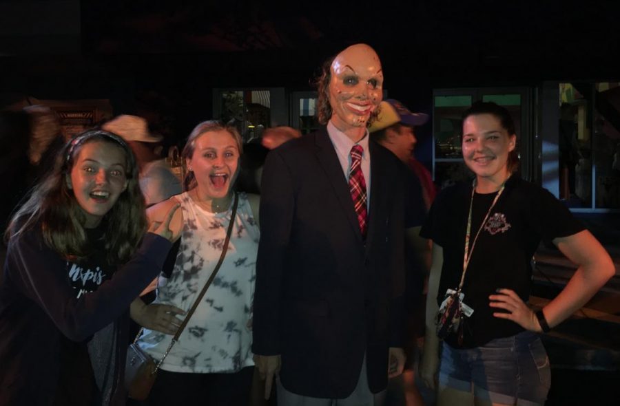 Junior Katie Jackson (right) and friends pose with Purge man. Scarers are prohibited to touch visitors while scaring and taking pictures. 