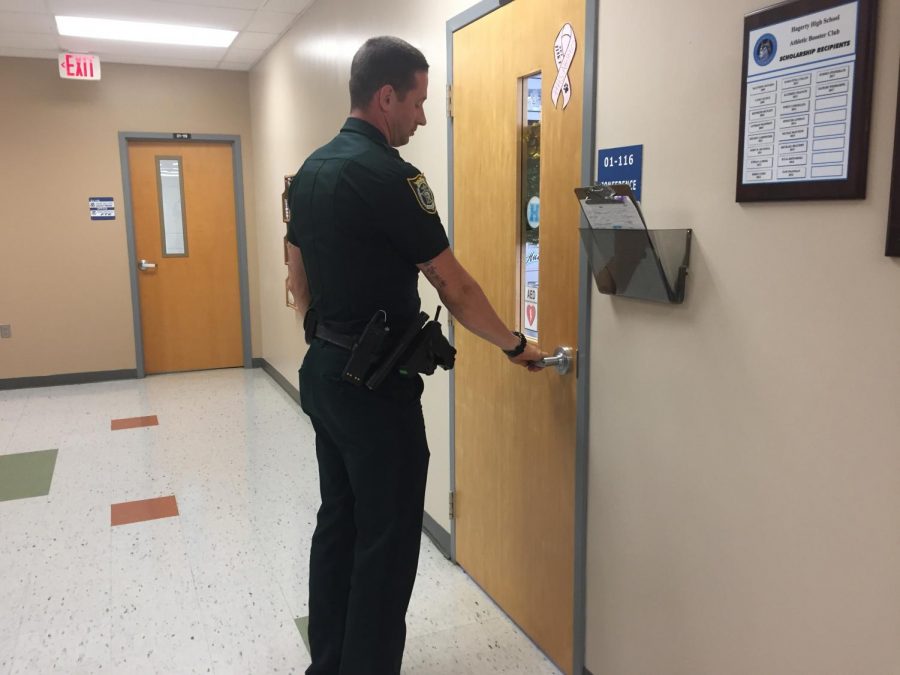 School resource officer David Attaway checks a door to make sure it is locked. Locked doors is among many safety precautions the school has taken. 