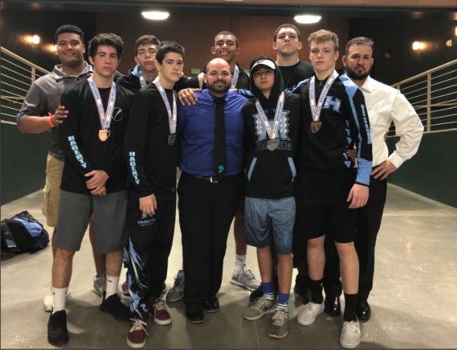 The seven wrestlers who went to states stand with their coaches. The team placed third overall, a program high.