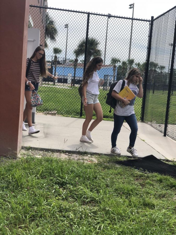 Sophomores Viviana Nute, Erena Loria and Maria Raptis walk out of their classroom before lunch. Displayed in the photo is the newly placed fence for student safety. 