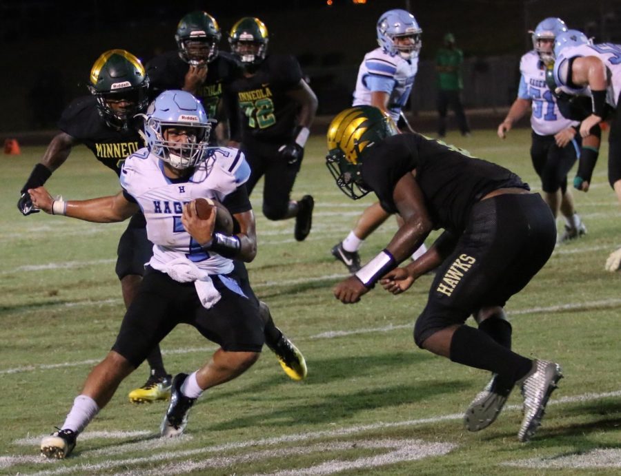 Quarterback Sammy Cordero evades Lake Minneola tacklers on one of his 20 carries. Cordero scored twice in the varsity teams 35-28 victory over Lake Minneola.
