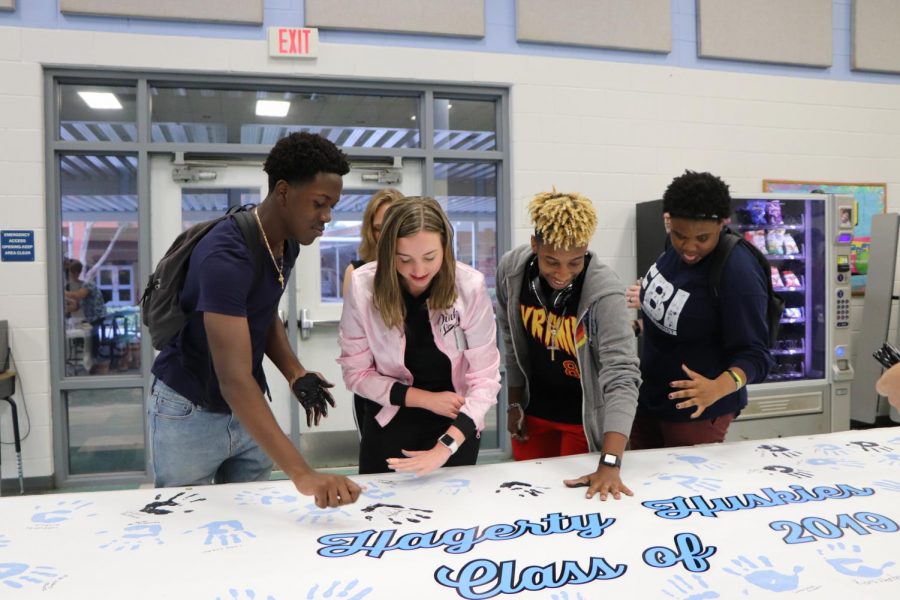  Seniors Jonathan Valentin, Katie Sherlock, DaZhaun Hicks and Jazmyne Essington put their painted handprint on one of the two banners for Paws on the Wall. 
