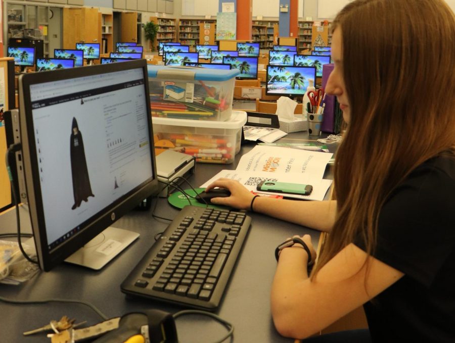 Sophomore Jolie Miller looks up capes on Amazon for the robotics team.