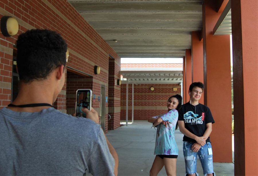 Senior Anna Cushman (middle)  makes a Tik Tok outside her 5th period with junior Sam Cosentini (right). Freshamn Schyler Arroyo (left) recorded the footage.