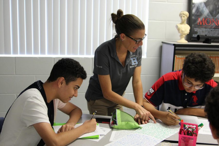  AP World History teacher Erin Foley helps sophomores Hakim Aburrashid and Diego Garcia with an assignment. 