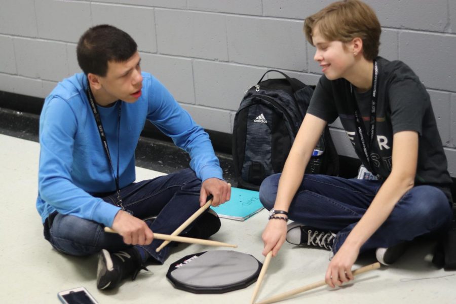 Sophomore Julia Shepp helps sophomore Jack Kimball with the drums during band. 