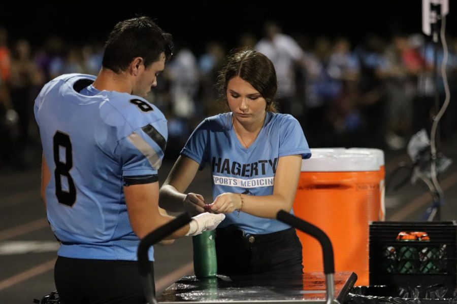 Senior Kathryn Peabody assists an athlete during a football game. 