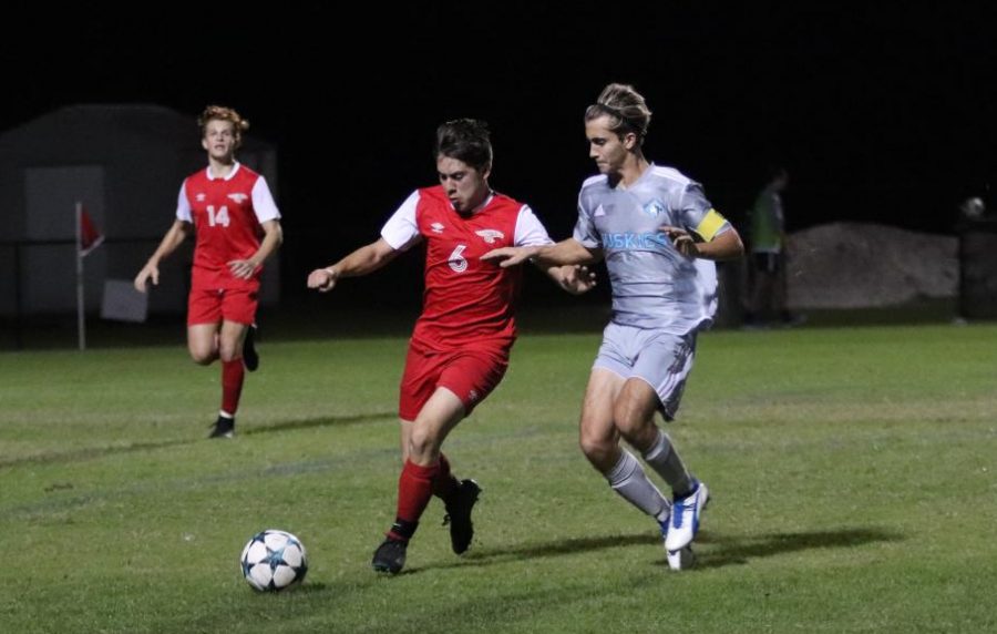Senior Parker Wickizer defends the ball against East River. The team won the game 2-1.