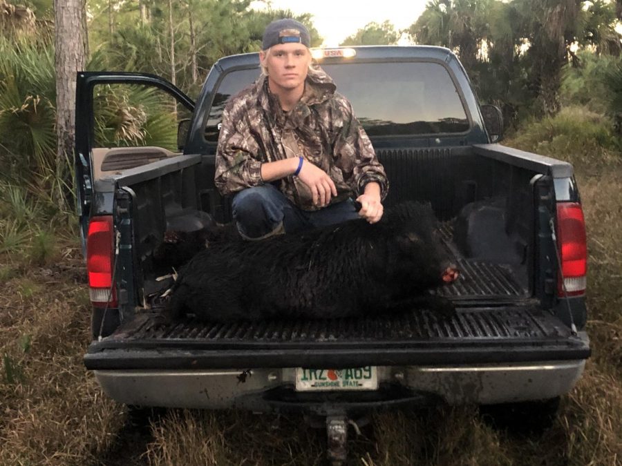 Senior Garet LaGrange poses with a wild hog he takes home. LaGange will usually hunt by waiting in a stand nearby animals or will drive around in the woods looking for game.
