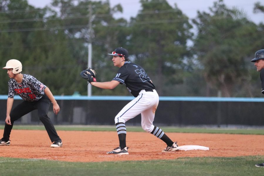 Ryan Carroll holds the runner close to first in the Tuesday game against Winter Springs.