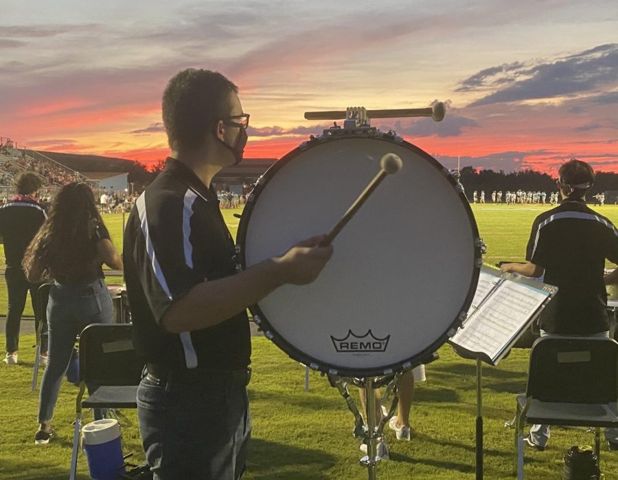 Percussionist Matt Hurley plays bass drum at a Friday night football game. Many band students are excited to participate in pep band.