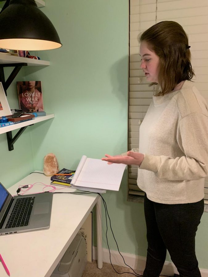 Freshman Grace uses her notes to perform her refutation speech. Notes are called flows as students record the flow of the round, writing who is speaking and what is being said.