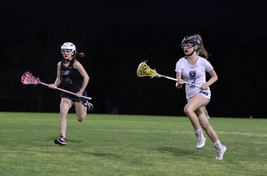 Midfielder+Carly+Bitner+runs+downfield+in+a+senior+night+game+against+Lake+Mary+Prep.+The+team+won+the+March+9+game+12-2.