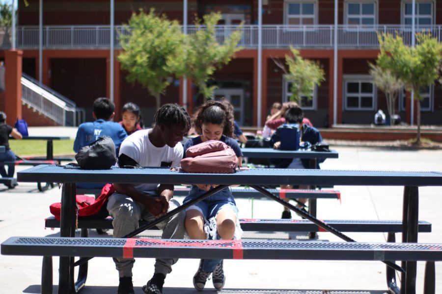 Two students are enjoying a new picnic table setup outside, due to new COVID-19 guidelines.