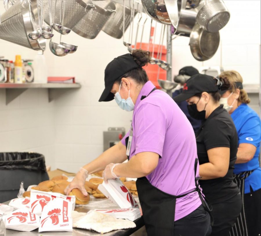 Cafeteria staff prepare chicken sandwiches for lunch. The staff prepare food three times a day for each meal opportunity on campus. 