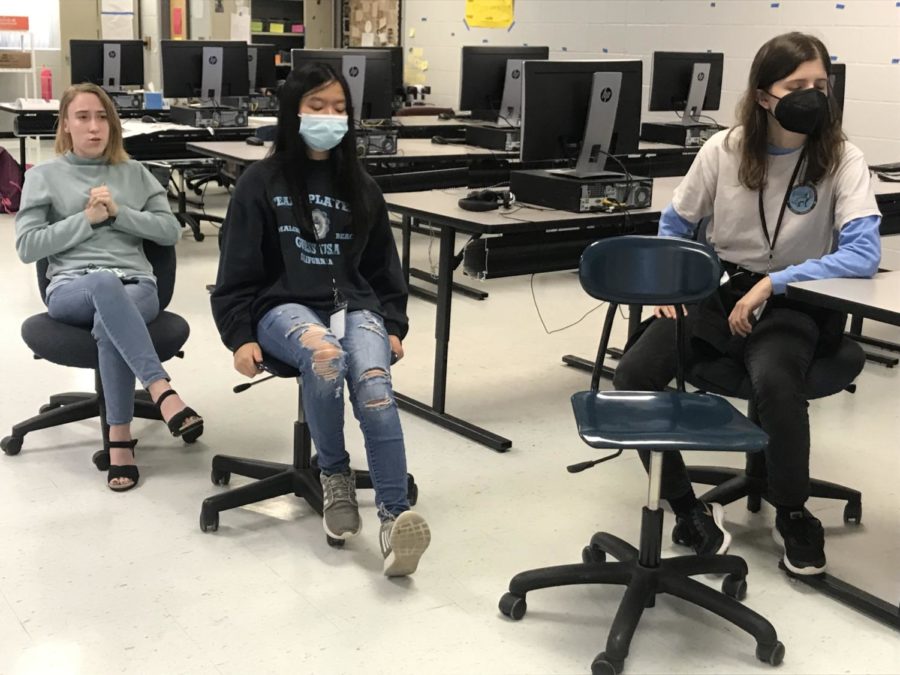 (from left) senior Bella Knowles, freshman Josephine Lim, and junior Hannah Kuerbitz listen to Hale as she speaks about the literary magazine. All three plan to become active members of the club. 