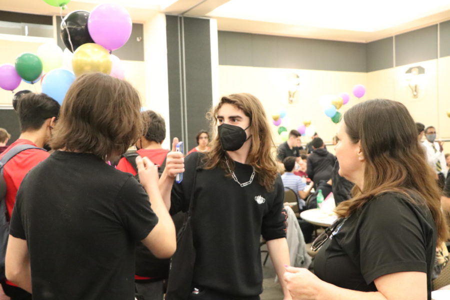 Sophomore Aidan Priore fist bumps his teammate after a successful day coding.  He and his team would win the honesty in scoring award at the UCF tournament.    