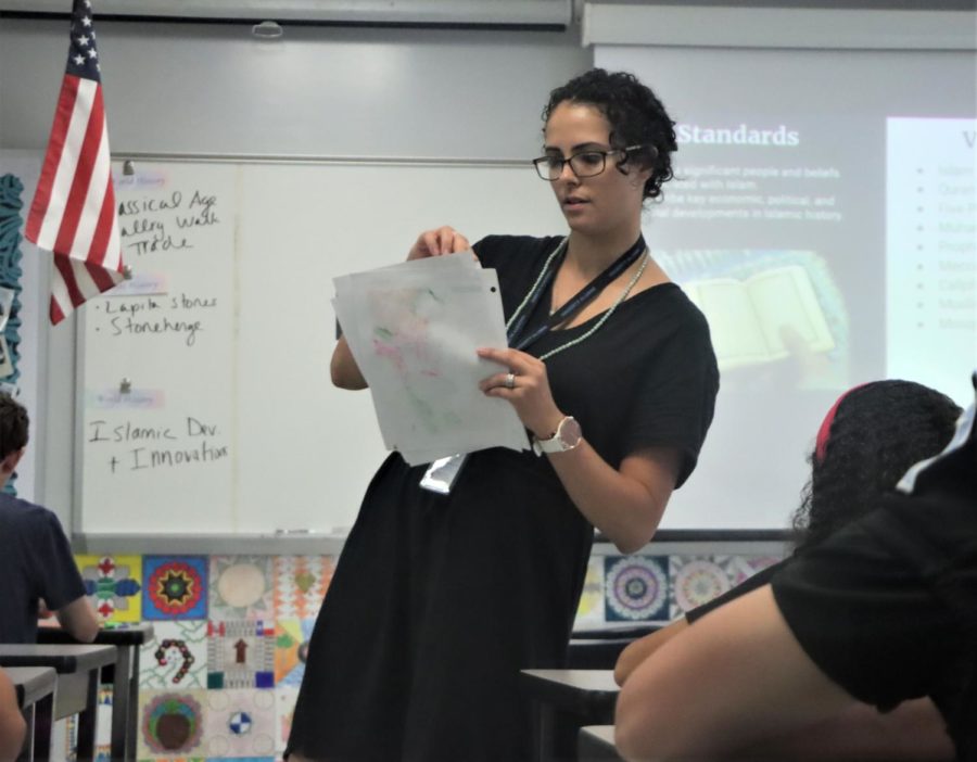 Furiosi passes out class material during her standard World History class. Taking over for former teacher Maria Coville, Furiosi also teaches AP Art History and AP World History.