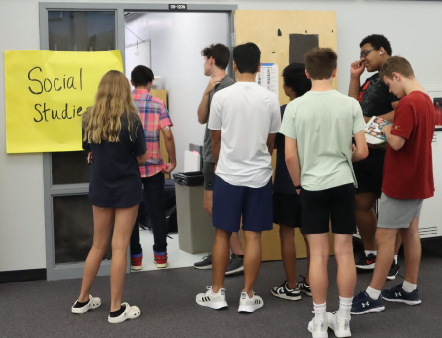 Students line up by the social studies room to check out their textbooks on Aug. 17. The media center distributed textbooks all week, with the help of student assistants and PTSA.