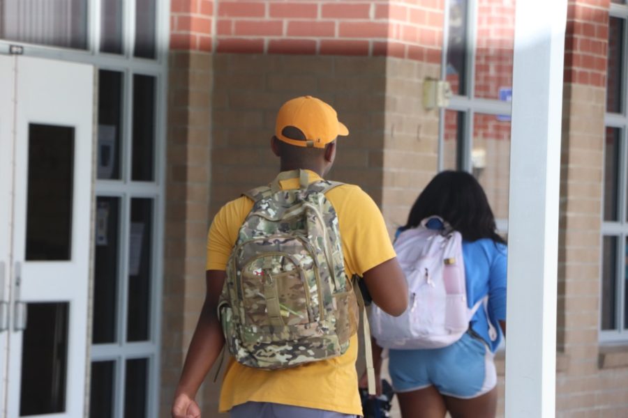 A student walks to class with a hat. As part of the new dress code, caps and hats are allowed. 
