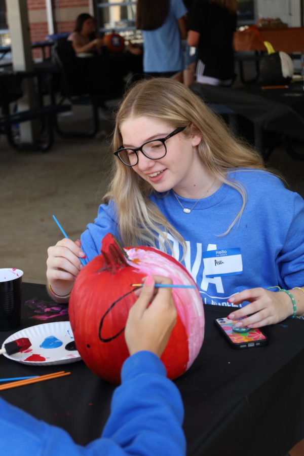Freshmen Ava Bess and Samantha Nicolas painting their pumpkin red, half Spiderman themed and half Captain America themed. The theme of the competition was superhero.