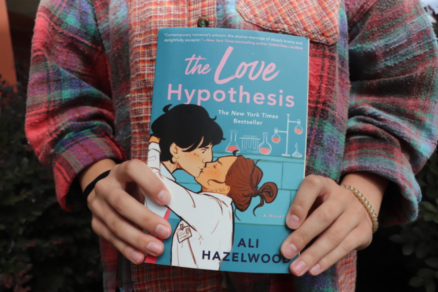 Senior+Lauren+Tait+holds+her+copy+of+The+Love+Hypothesis+by+Ali+Hazelwood.+Tait+read+the+book+over+a+weekend+during+the+summer+and+loved+it.+