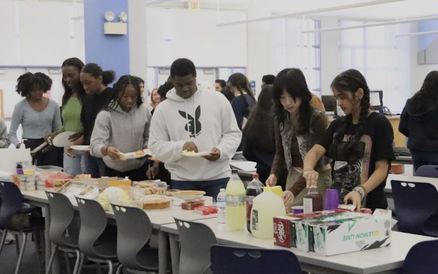 Both Black Student Union and Hispanic Student Union members line up to fill their plate with potluck items brought in by members. Both clubs collaborated for this event in hopes to encourage members to make new friends and feel a part of a community. 
