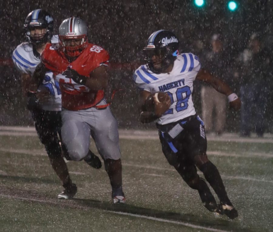 Senior Jeremiah Williams runs the ball during the first half of the game against Lake Mary. Constant rain in the first half disrupted the offense and led to a couple of turnovers in the 28-0 loss.