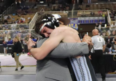 Head coach Scotty Diaz and senior Kamdon Harrison hug after Harrison won his wrestling match to place third in the state. 