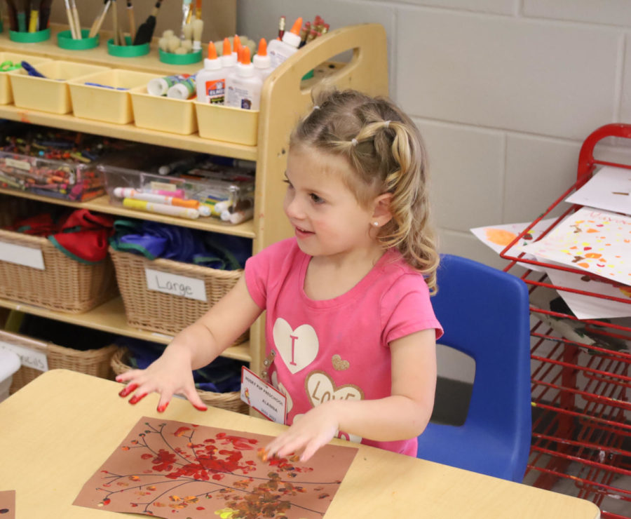 A Husky Pup Preschooler plays with finger paint during class time. Early Childhood Education students are able to interact with and support the Husky Pup students to gain classroom experience with children.