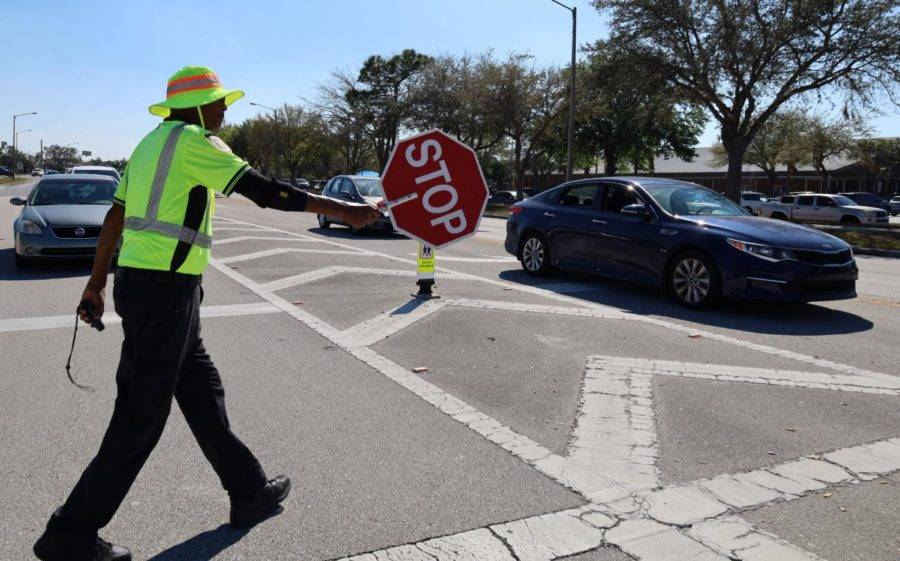 Crossing guard Larry Miller stops traffic after school for students to cross the street. Miller was voted as the top crossing guard in the state last February.