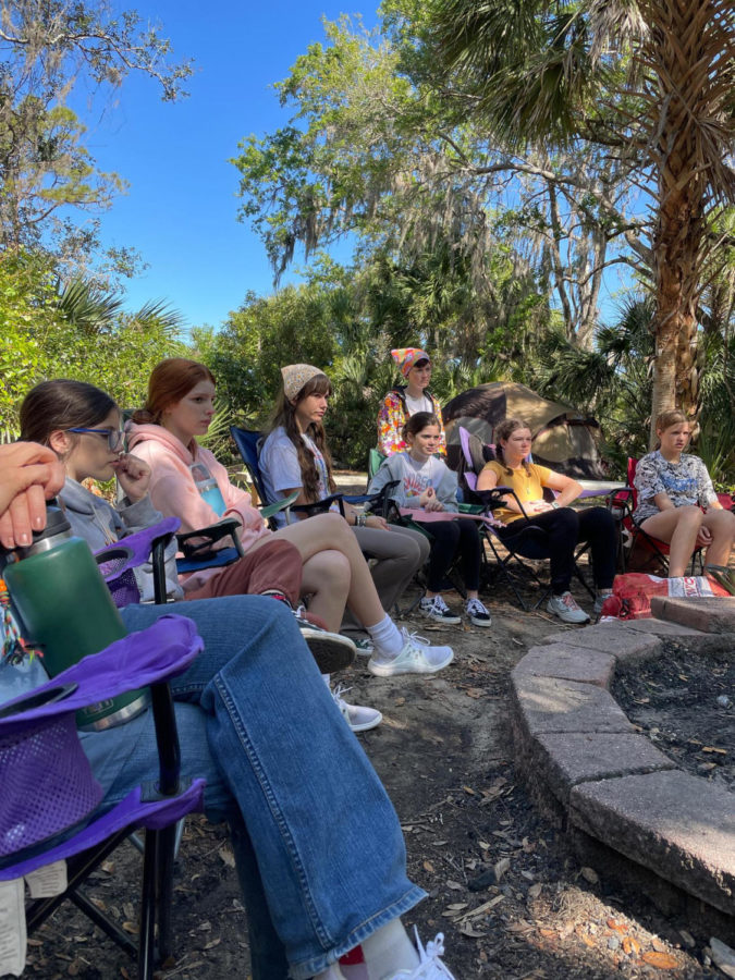 Bohan and other Latter-day Saints sit outside and talk at girls camp in March. Bohan says that events like these help young girls better themselves.