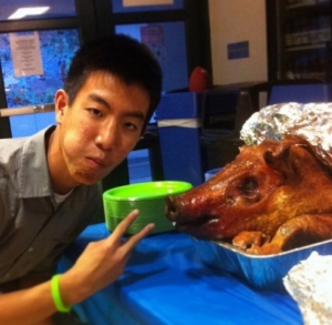 Sophomore Cameron Yap poses with a pig to commemorate his sister's cancer remission banquet.