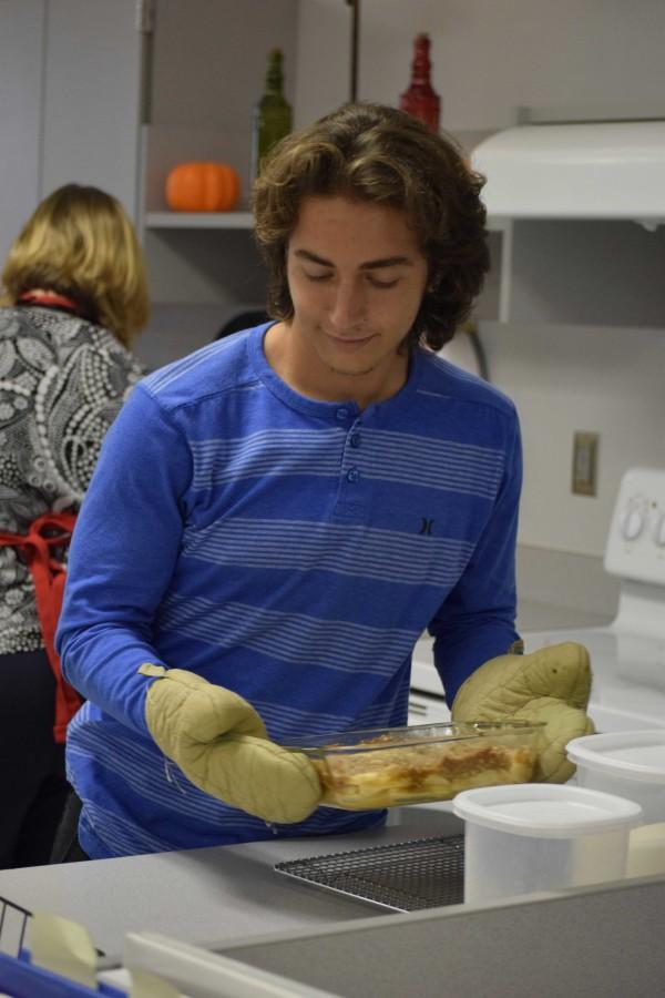 Junior Trey Hogan takes apple crisp out of the stove to cool before serving it to his peers.