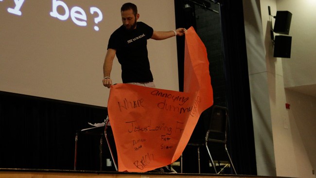 Head of To Be Kind, Inc. Adam Sherman rips up a piece of paper with hurtful words on it as part of his presentation on promoting kindness in schools.