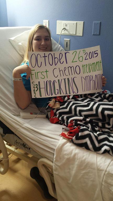 10/26/15- Baltz holds up a sign with a smile on the day of her first round of chemotherapy at Arnold Palmer Hospital. 