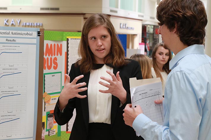 Junior Tess Marvin explains her project to a judge at the 2016 SCPS Regional Science, Math and Engineering Fair on Feb. 13. Marvins Molecular and Cellular Biology project was judged by a variety of experts in different fields.