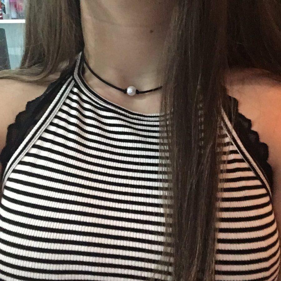 Freshman Annie Trimboli photographs her new black choker pearl necklace that she had made. Trimboli has sold over 70 these chokers for $3.