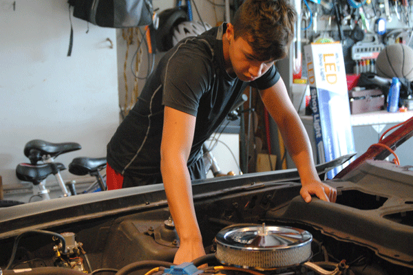 Sophomore Shane Halligan works to restore the engine of his ’71 Mustang. Halligan plans to bring the car to school as part of his Genius project.