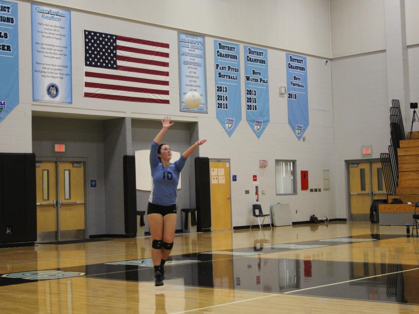 Sophomore Madison Coates serves the ball over the net. The team defeated St. Cloud 3-0.